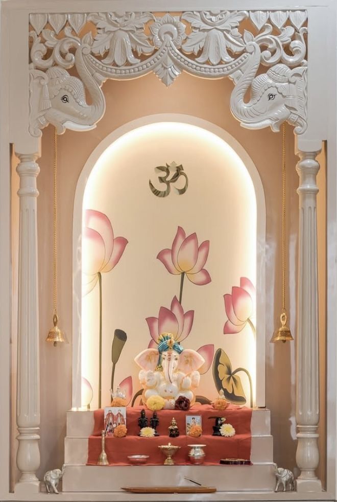 Clean and beautifully decorated pooja room with lit lamps and fresh flowers